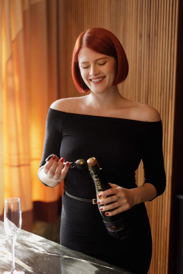 Photo of Lucy Huxley with bottle of champagne